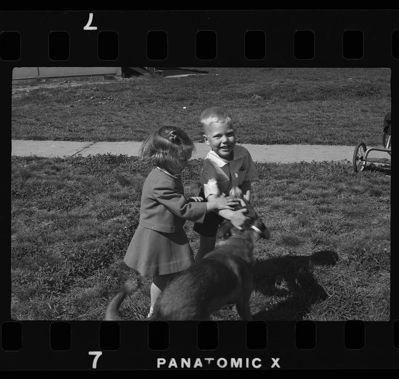 Two children playing with dog