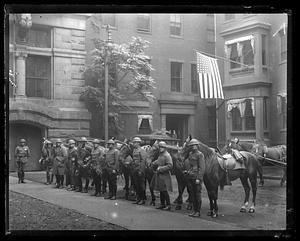 Soldiers standing with their horses in a row