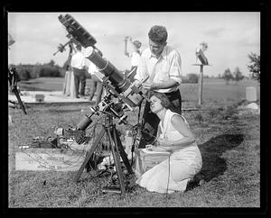 Woman looking through a telescope