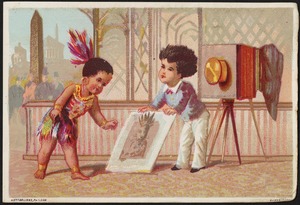 Boy in native dress being shown a photograph by him by a photographer.