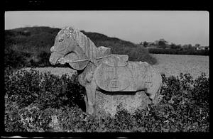 Stone animal carving in field