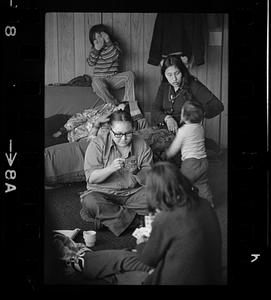 Two women play cards, women and children in background, Alaska