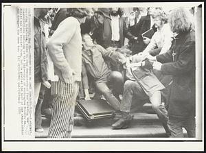 Student Tries to Stop Demonstrators -- A student, carrying briefcase, tried to stop demonstrators from entering the Communications Building at the University of Washington Monday. He failed and was knocked down, but he grabbed the hair of one demonstrator and dragged him down too.