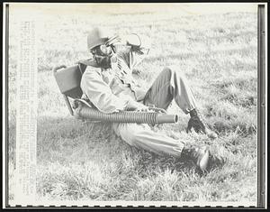 An unidentified Guardsman rests on the ready with gas spraying equipment and protective gear as National Guard troops and State Police enforced the second night of curfew on University of Kentucky campus.