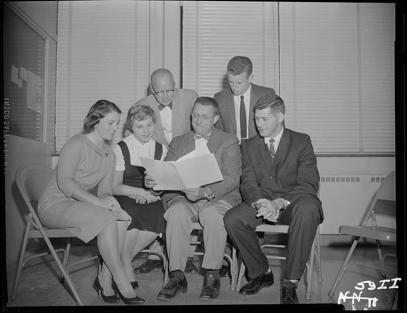 People gathered around man with manuscript