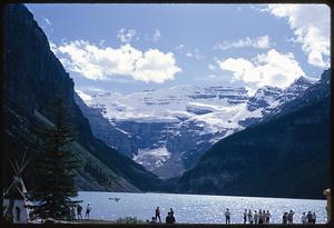 Snow-capped mountain with lake and people in foreground, British Columbia