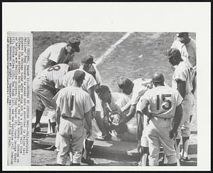 Injured by Pitched Ball -- Philadelphia Phillies' Tony Gonzales is eased onto a stretcher by fellow ball players in Chicago today after being hit by a pitched ball from Chicago Cubs pitcher Dick Ellsworth in the sixth inning. Looking on or helping are Phillies players; Tony Taylor (8), Coach George Myatt (1), Richie Allen (15), Don Hoak (12), and Wes Covington (43) leaning over Gonzalez at right. Gonzalez was carried off the field.