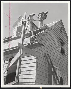 Houses Take Shape Again after destructive tornado which destroyed several thousand central Massachusetts homes. These carpenters are shingling the roof of a house on Glen terrace in Shrewsbury.