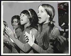 Cheering Brookline on are cheerleaders, from left to right, Linda Bryant, Thomasina Benson and Eileen O'Connell in Suburban League hockey game against Newton at Boston Arena.