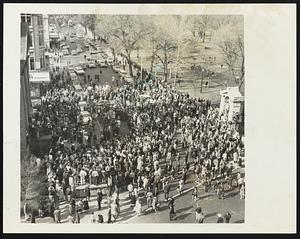 Overhead view shows egg-throwing crowd of some 1,000 that hooted the arrival of an equal number of marchers who hiked from Cambridge to the Arlington St. Church (L) of protest American policy in Vietnam. As pacifist filed into the church for protest meeting, they were pelted with eggs and beer cans. Traffic had to be detoured away from Arlington St.
