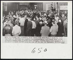 Workers Leave Struck Steel Mill -- Workers leave the South Side Works of the Jones and Laughlin Steelcorporation as a nationwide steel strike officially begins today, a minute after midnight. A crowd (foreground) assembled in the street to watch the CIO union men come off the job.