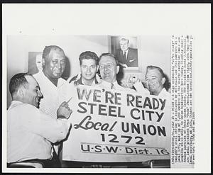 Ready - A sign announcing "we're ready" for tonight's steel strike is displayed by officials and steelworkers at a Local 1272, made up of 5,000 workers at the nearby southside Jones and Laughlin steel mill, in union headquarters here today. Standing under a framed portrait of their union leader, USW President David J. McDonald, are local president Evan "Buck" Jones, second from right, with Tony Zema local secretary, at left. Others are not identified.