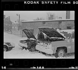 Man working on car during snow storm