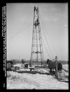 Wachusett Department, Wachusett-Sudbury power transmission line, Sudbury Reservoir crossing, erecting 68-foot steel tower at southwesterly end of 700-foot span, preparing to raise top section, Southborough, Mass., Dec. 20, 1917