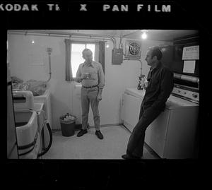 Two men in laundry room, North Slope camp, Anchorage, Alaska