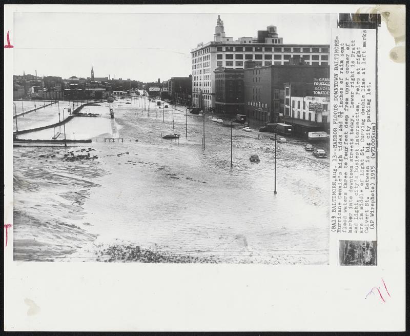 Harbor Floods Downtown Baltimore -- Hurricane Connie's high tides and 8 1/2 inches of rain sent flood waters three to four feet deep from upper corner of harbor into downtown street today. Lower right is Pratt and Light, city's busiest intersection. Poles at right are in middle of Light St. Curving double line left marks Calvert St. Between is big city parking lot.