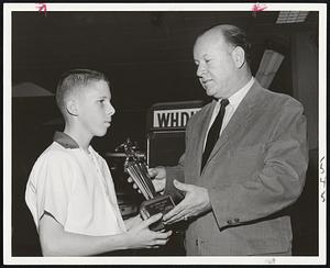 Junior Star of TV bowling, Danny Murphy, in familiar pose as he accepts one of nine trophy awards from Jim Britt, MC of Channel 5 Winning Pins show. Murphy, 12, seeks 10th straight win today.