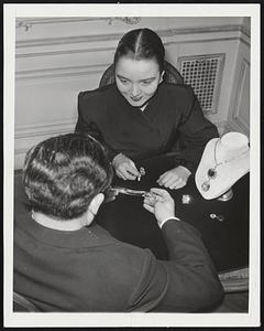 Millions in Gem Collections Two of the world's most famous diamonds, the 44 1/2-carat Hope and the 100-carat Star of the East, top and bottom, rest on the little stand at right in the New York office of Harry Winston, world famous dealer in gems. Winston, back to camera, is showing other jewelry to Miss Georgina Dewey. (Winston is prohibited by the terms of his insurance from having his picture taken).