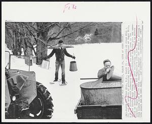 Sugaring on Sugar Hill - Old an new methods of gathering maple sap are combined at Sugar Hill, N. H., a 200-year-old community now become the newest town in the Granite State. Gary Young uses an old-fashioned shoulder yoke and snowshoes as Ross Coffin pours sap into collecting tanks hauled by modern tractor. Sugar Hill became New Hampshire's 224th town after separation from Lisbon nine miles away recently. Sugarin' off season is getting a late start due to deep snow.