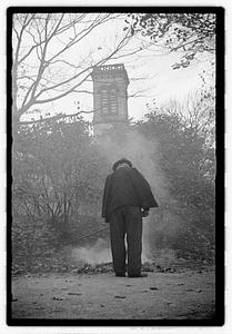 A man raking and burning leaves