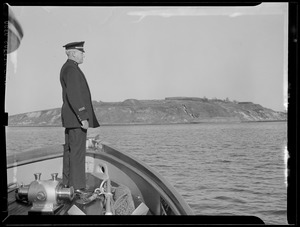Officer on bow of ship off Governor's Island