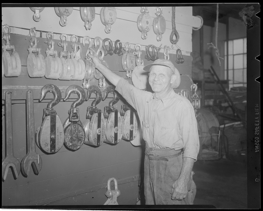 Man with tackle and blocks, boatyard