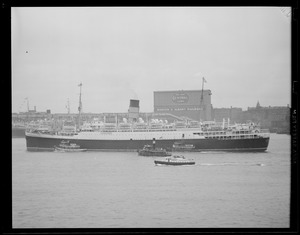 Liner guided into Boston Harbor by tugs