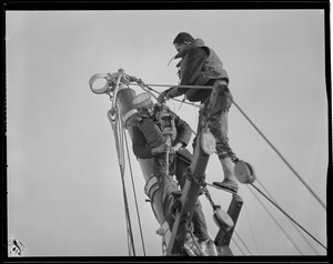 Men climb mast of sunken ship "O'Hara"