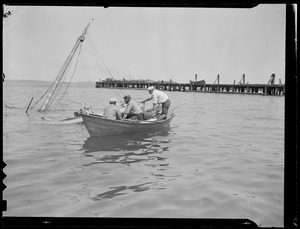 Men row out to sunken boat