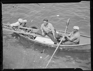 Men row out to sunken boat