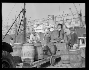 Waterfront: Men at a loading dock - Fish Pier - South Boston. Waterman Line steamship in background at Comm. pier no. 5