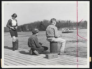 Camera Catches Fishermen-Judy Salent, 19, Holliston gets an “action” shot of Andre Bonnell, 13, and Peter Vaughan, 13, both of Natick, who yesterday found fine fishing weather at the Lake Cochituate state park.