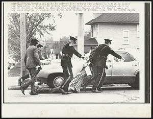An unidentified motorist is dragged to a waiting police car 5/14 after he injured 10 persons when he swerved into a crowd of students marching toward the State Capitol to take part in an antiwar demonstration. Of the 10 taken to the hospital, 9 were released and 1 girl kept because of a broken rib.
