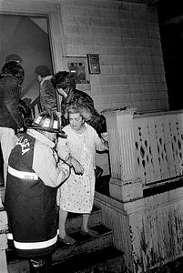 Firefighters Anthony, Nemic, and civilians Gary Saunders, Arthur Rosenberg evacuate Betsy Siegal from one of the fire buildings