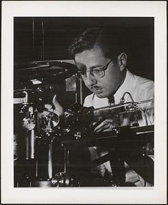 A scientist at the Naval Research Laboratory makes a delicate adjustment on one of the many pieces of complicated equipment used in various experiments conducted at the laboratory