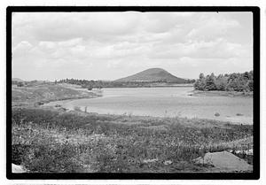 A body of water, a hill in the distance