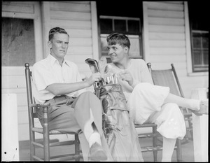 Two golfers sit on porch
