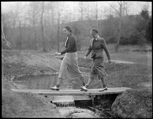 Two women cross stream on course