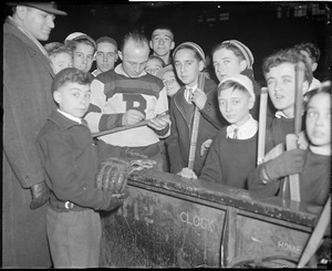 Eddie Shore of the Bruins signing a stick for a kid, Boston Garden