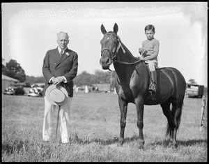 Grafton Smith with boy on horse holding trophy