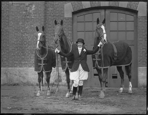 Woman in riding gear with three horses