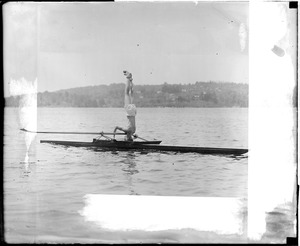 Man stands on head on scull, Charles River