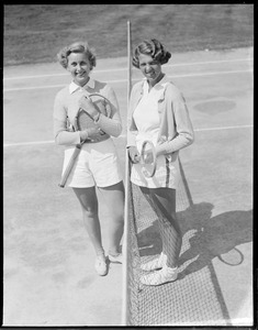 2 women carrying rackets