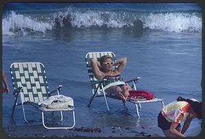 Woman lounging on beach chair, Revere Beach