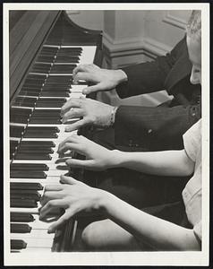 Brilliant Fingers. Two pairs of masterful hands are shown here as Jose Iturbi, famous pianist, gives instruction to Peter Paul Loyanich, 10-year-old prodigy of San Jose, Calif. Peter Paul will make his professional debut in New York on Jan. 29.