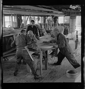 Pert Lowell, right, and others working in boat shop