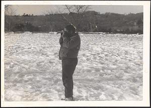 Young person taking pictures in the snow