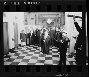 Crowd and officers in hallway by elevators