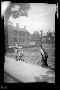 A man looks toward two standing women