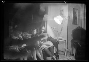 Five women sit on a couch by a lamp